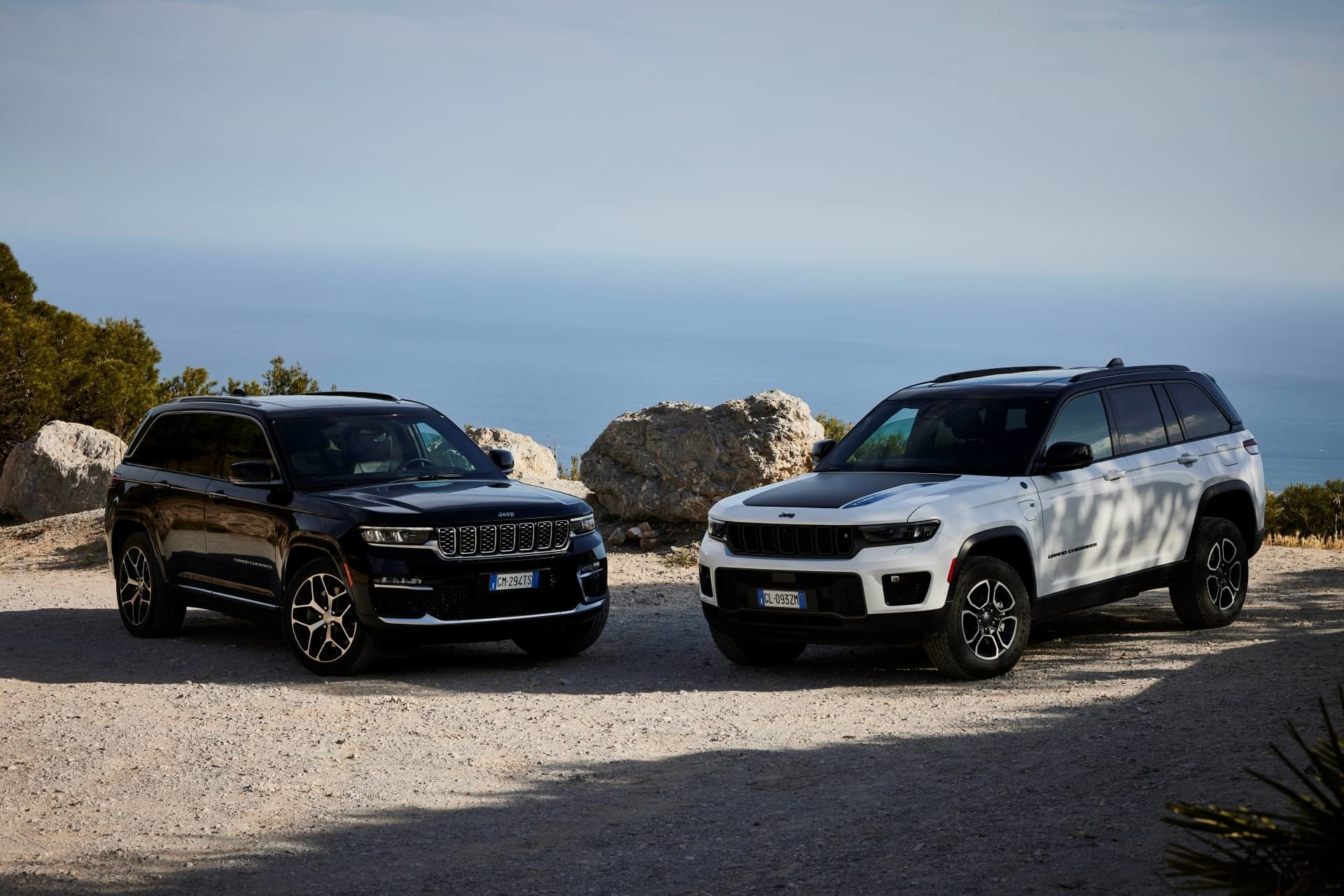 Dos Jeep Grand Cherokee aparcados frente al mar, vista delantera lateral.