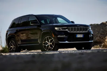 Vista dinámica del Jeep Grand Cherokee, mostrando su frente robusto y líneas laterales.