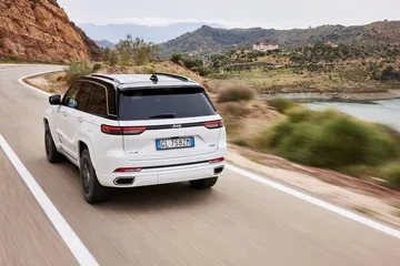 Vista dinámica de un Jeep Grand Cherokee desde una perspectiva trasera y lateral.