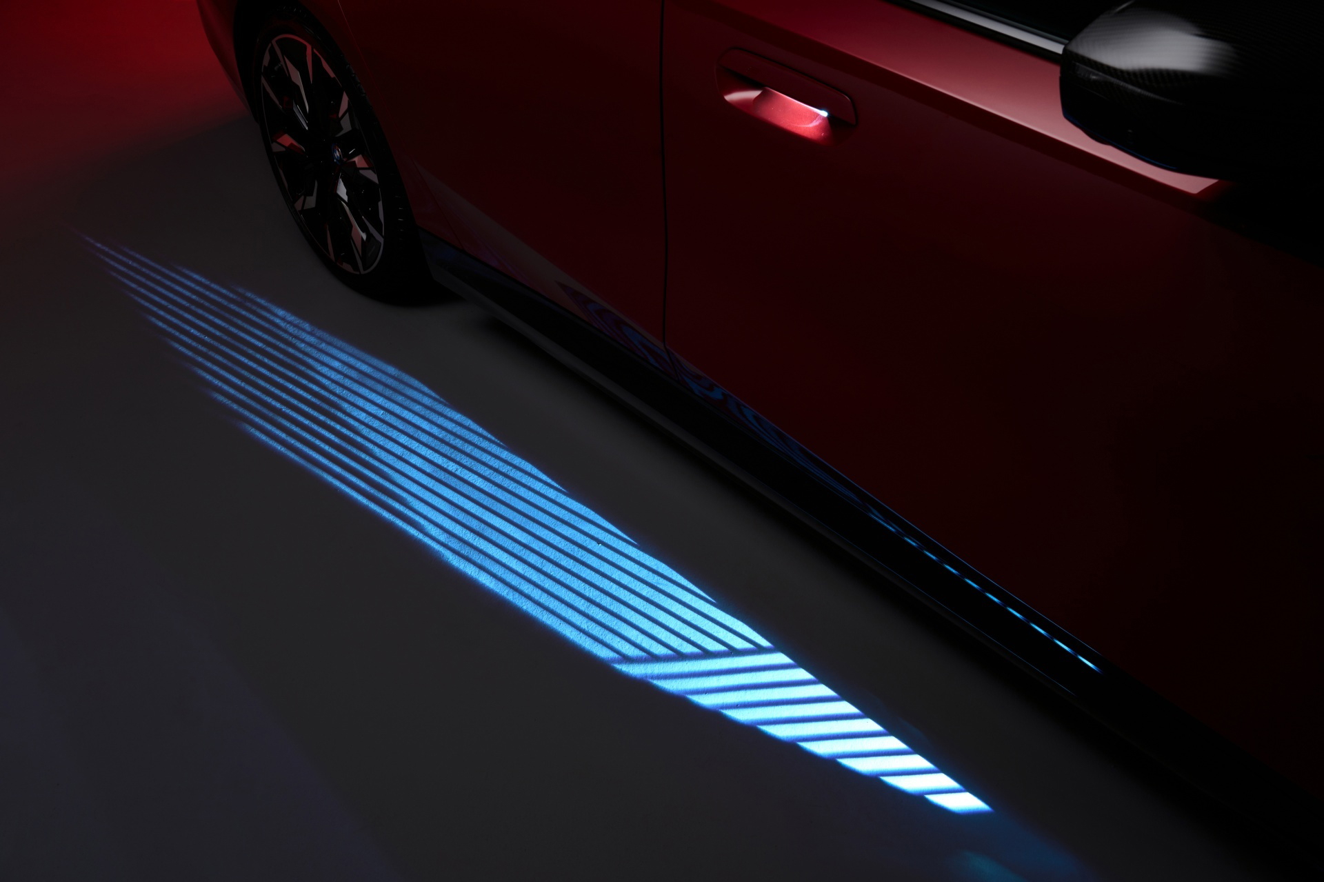 Proyección del logo de BMW desde la puerta, detalle moderno y tecnológico.