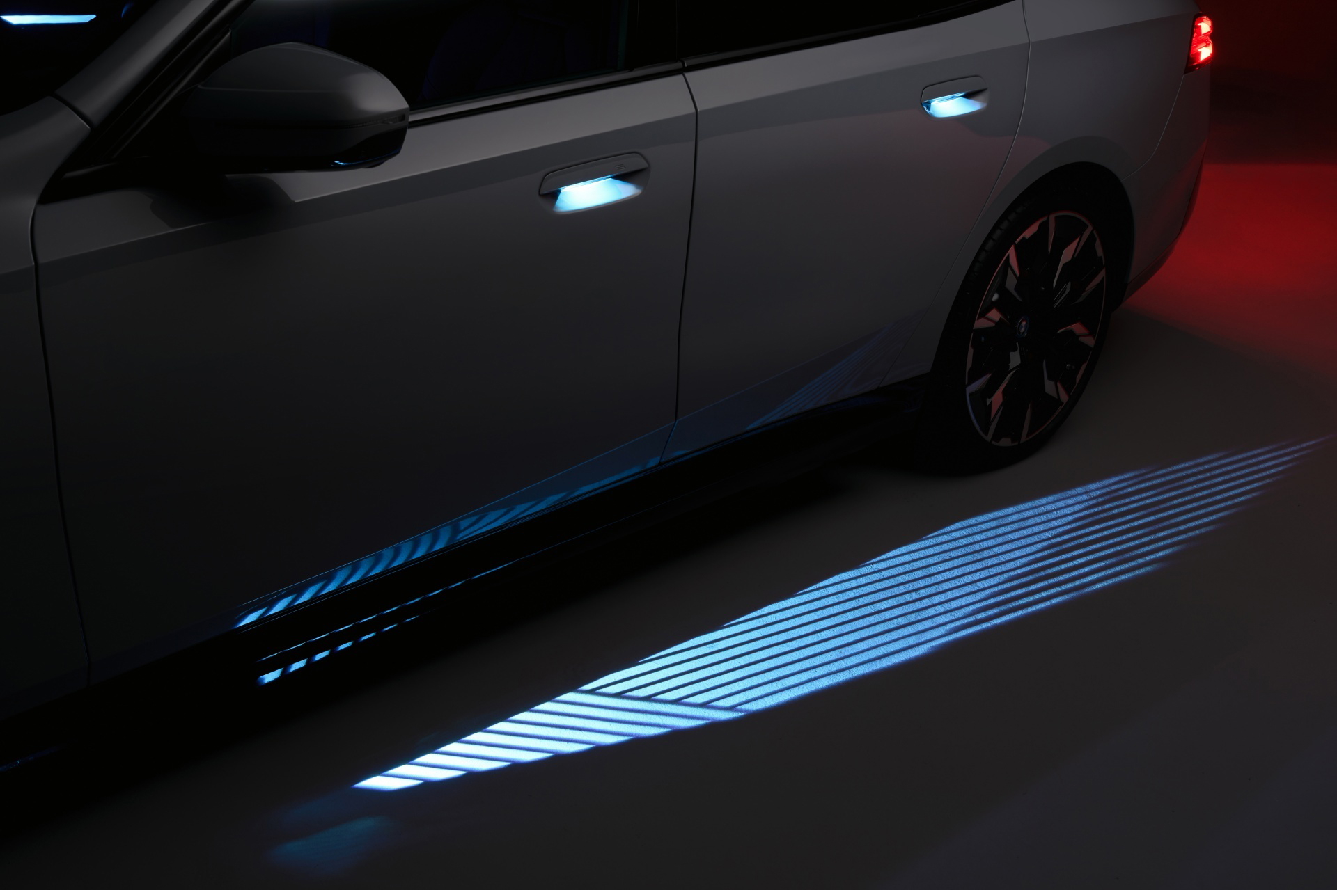 Luz de bienvenida proyectando el logotipo de BMW en el suelo al abrir la puerta.