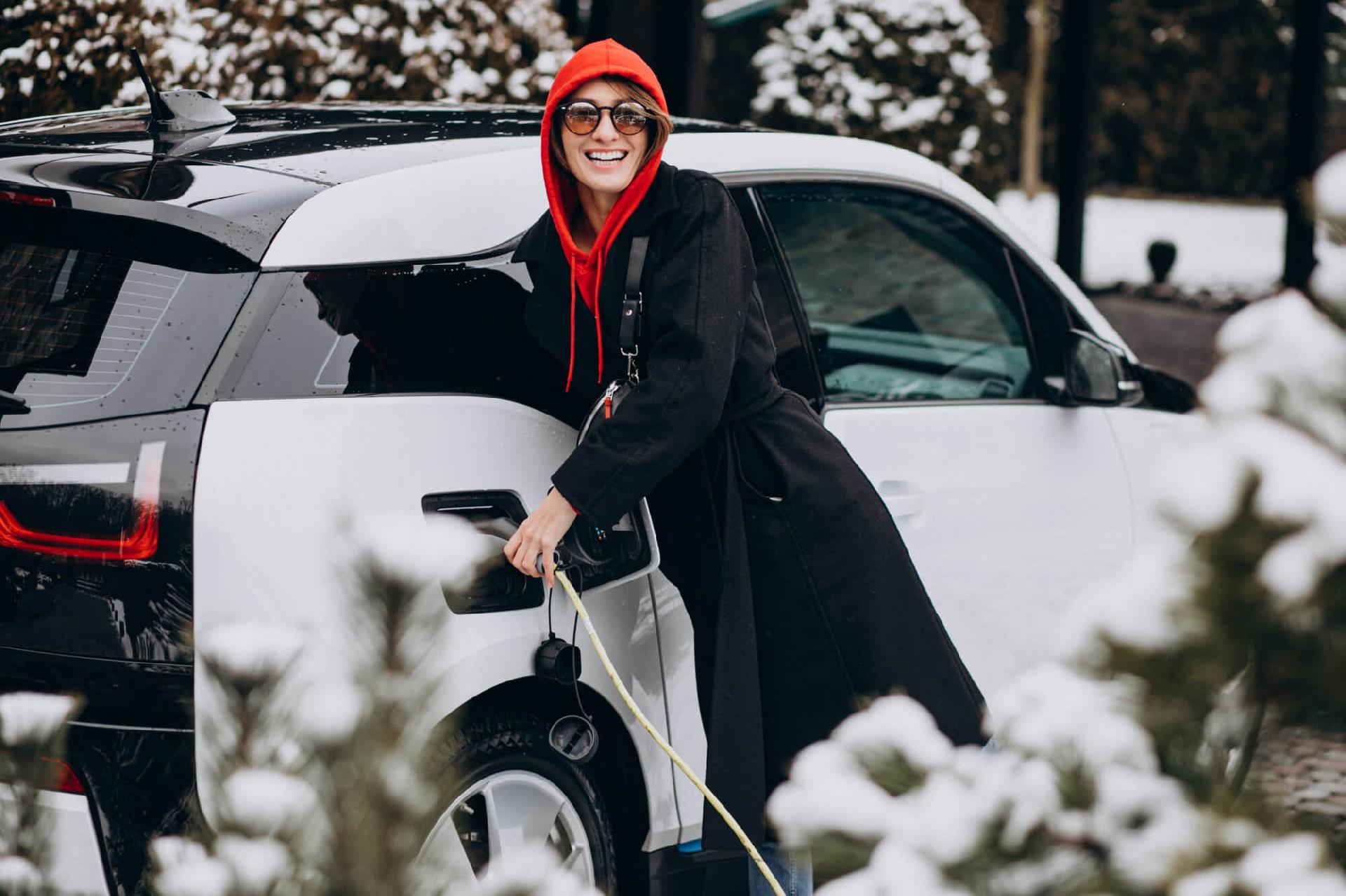Mujer-cargando-coche-electrico-en-la-nieve-64af5280e8394