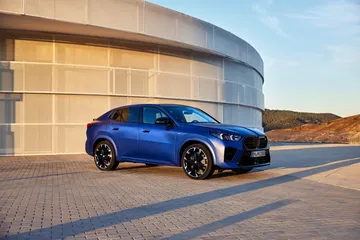 Vista lateral del BMW X2 en un entorno urbano, destacando su línea deportiva.