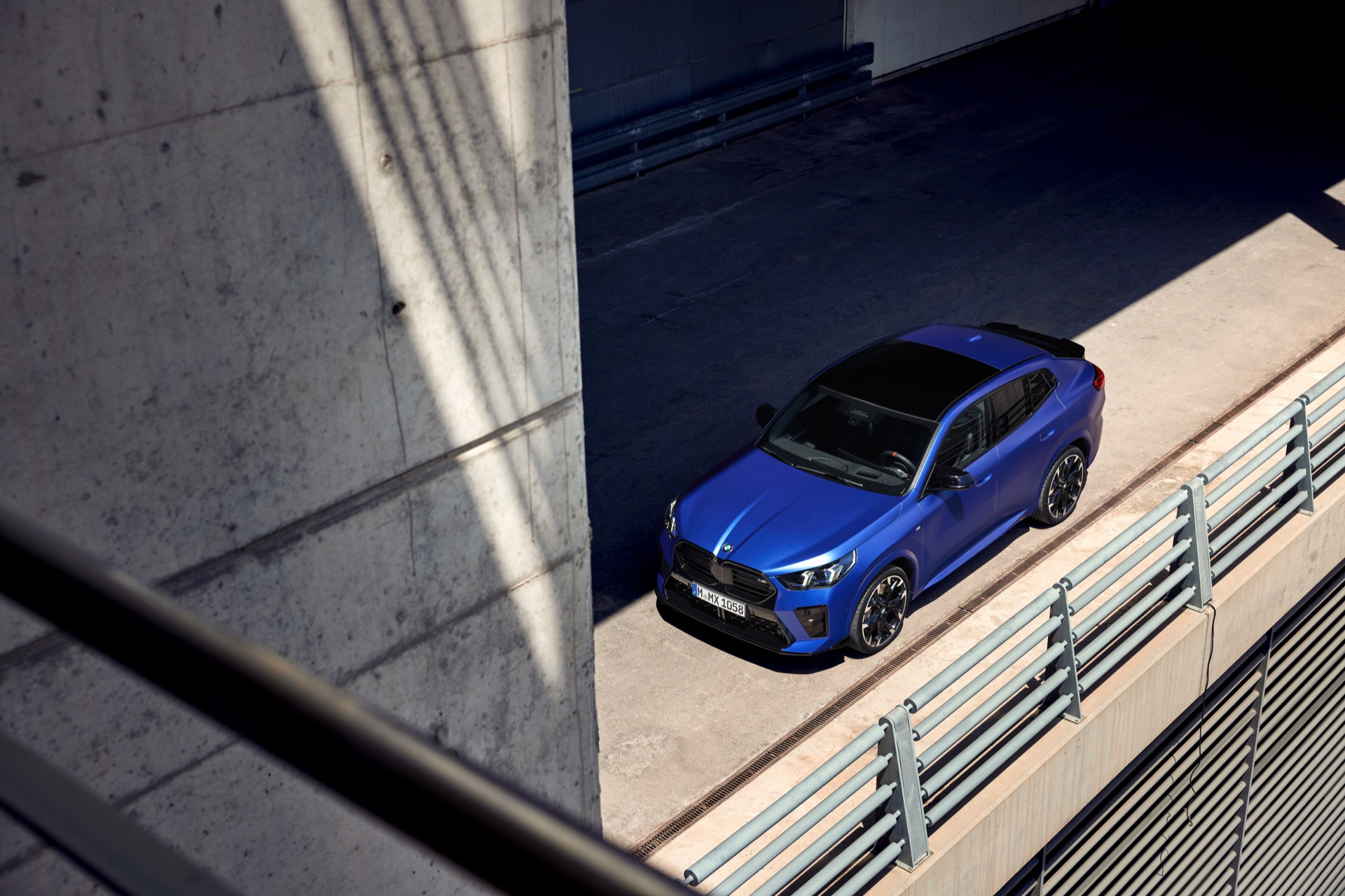 Vista aérea lateral de un BMW X2 en color azul estacionado.