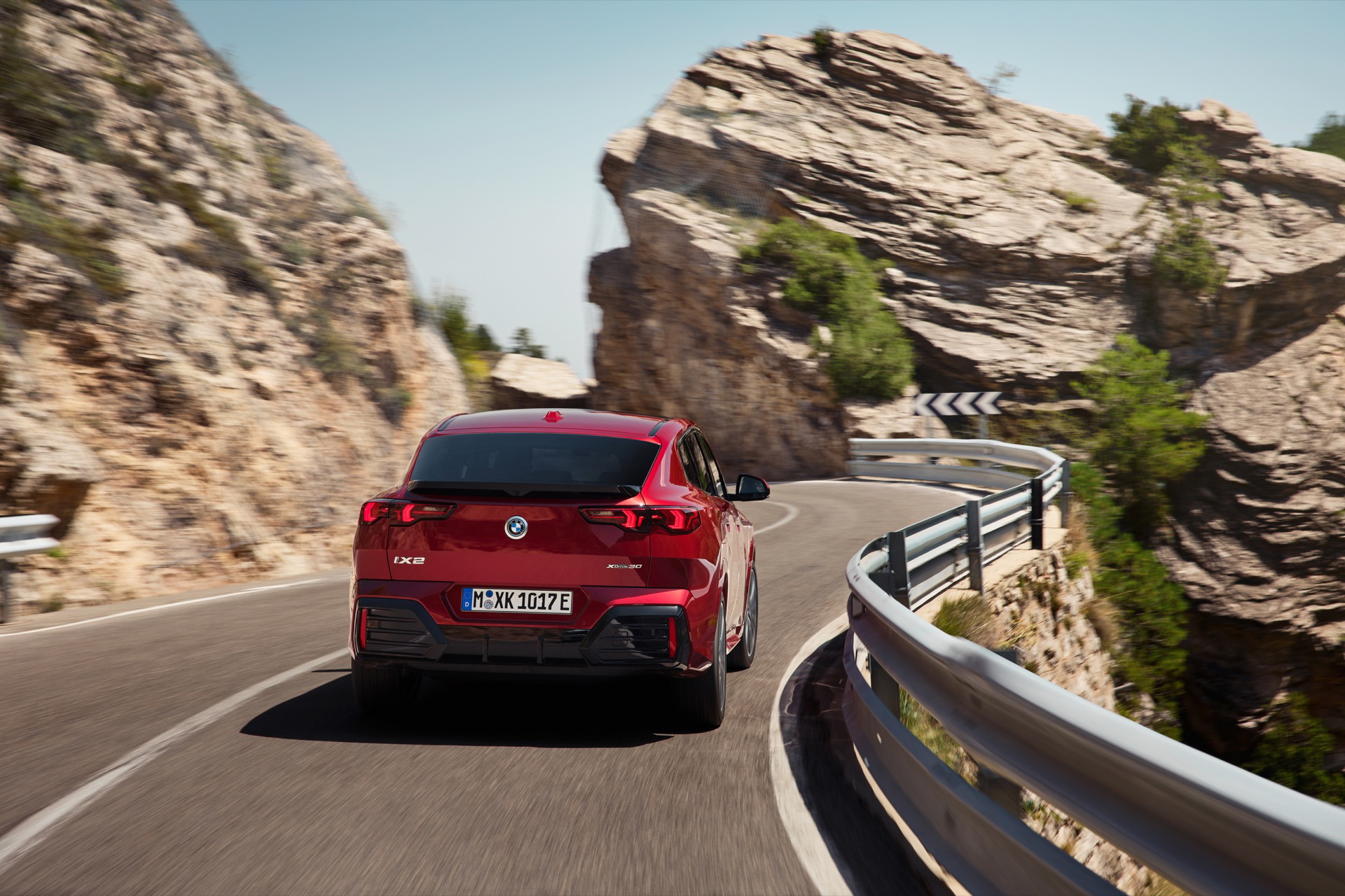 Vista dinámica del BMW X2 mostrando su parte trasera y lateral en carretera.
