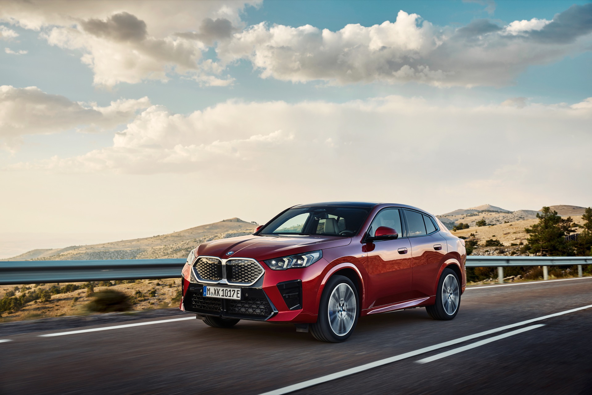 BMW X2 captado en movimiento mostrando su perfil lateral en carretera.
