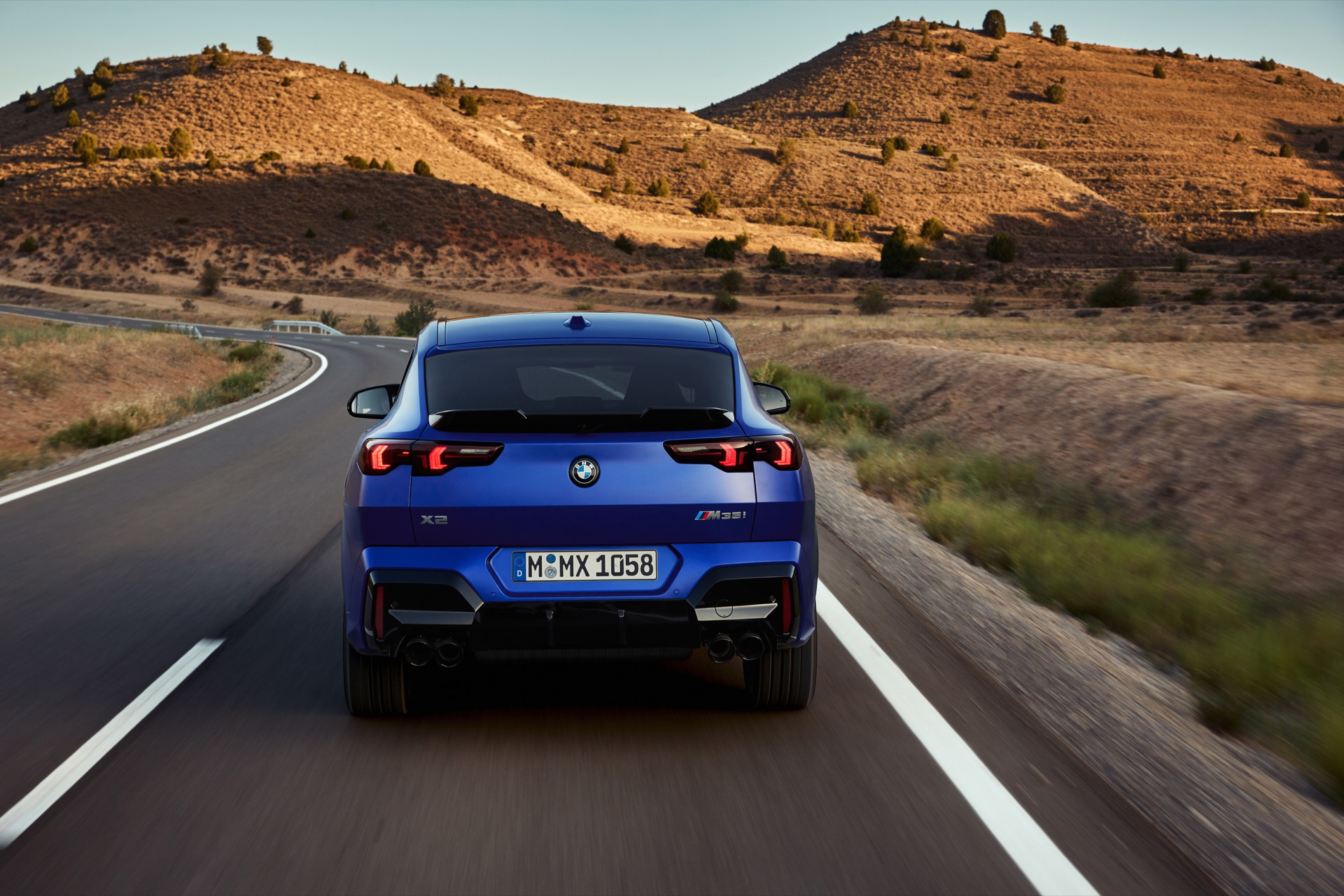 Vista trasera del BMW X2 en carretera, destacando su diseño deportivo.