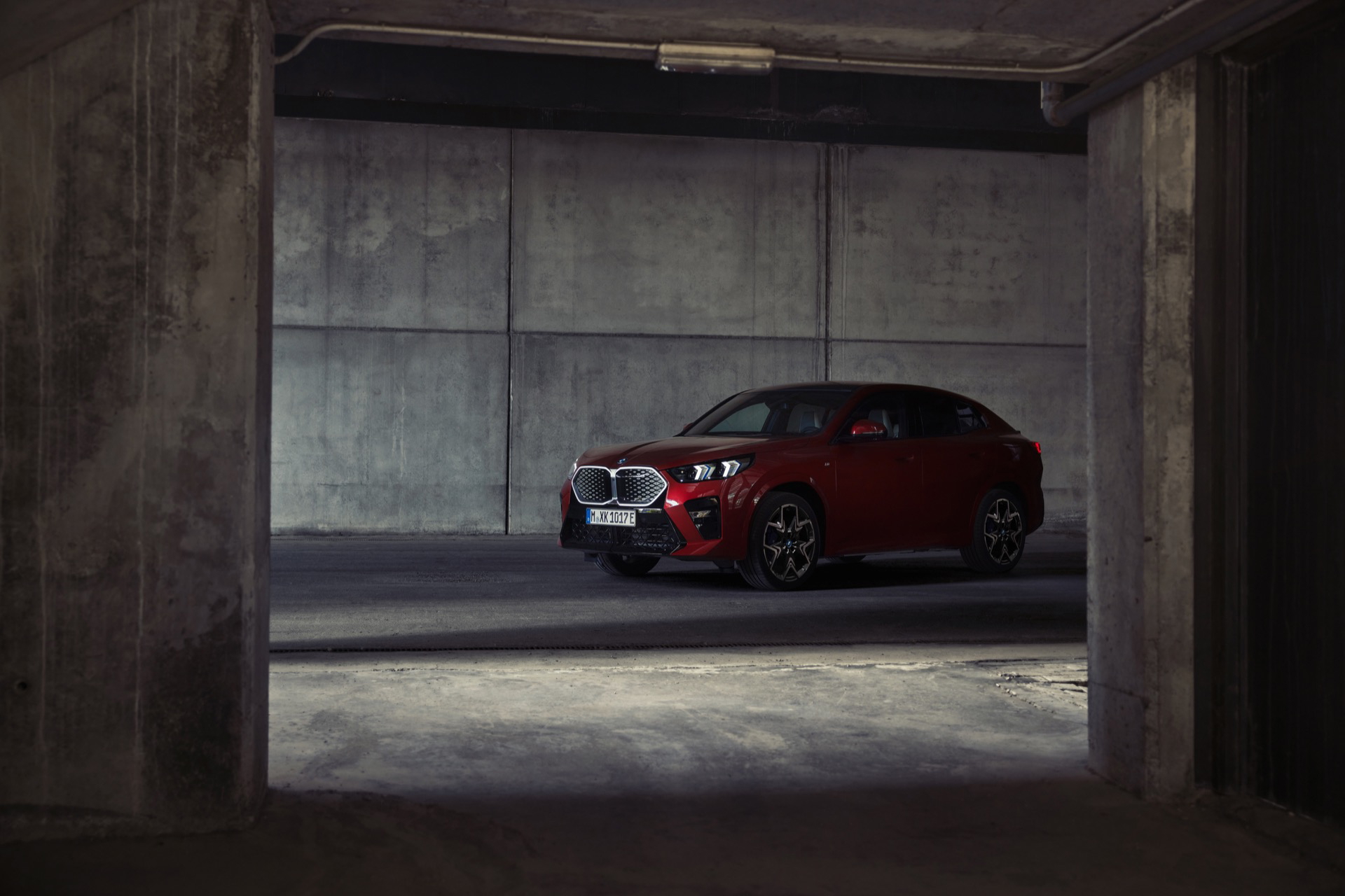 Vista lateral del BMW X2 en un ambiente oscuro de garaje, destacando su diseño deportivo.