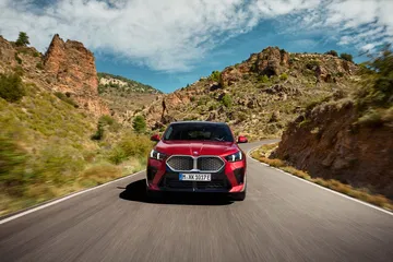 Vista dinámica del BMW X2 desde una perspectiva trasera y lateral.