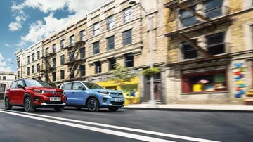 Dos modelos Citroën C3 y ë-C3 aparcados a un lado de la calle, mostrando su frontal y perfil.