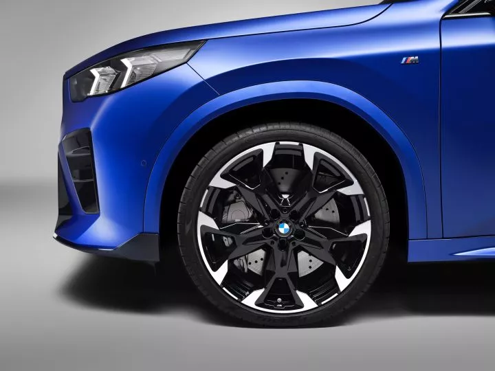 Vista de la rueda delantera y parte de la carrocería azul del BMW X2.