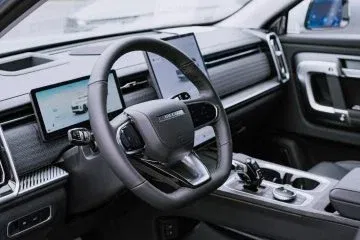 Vista del volante y consola central del JAECOO 7, destacando su ergonomía y tecnología. Vista del volante y consola central del JAECOO 7, destacando su ergonomía y tecnología.