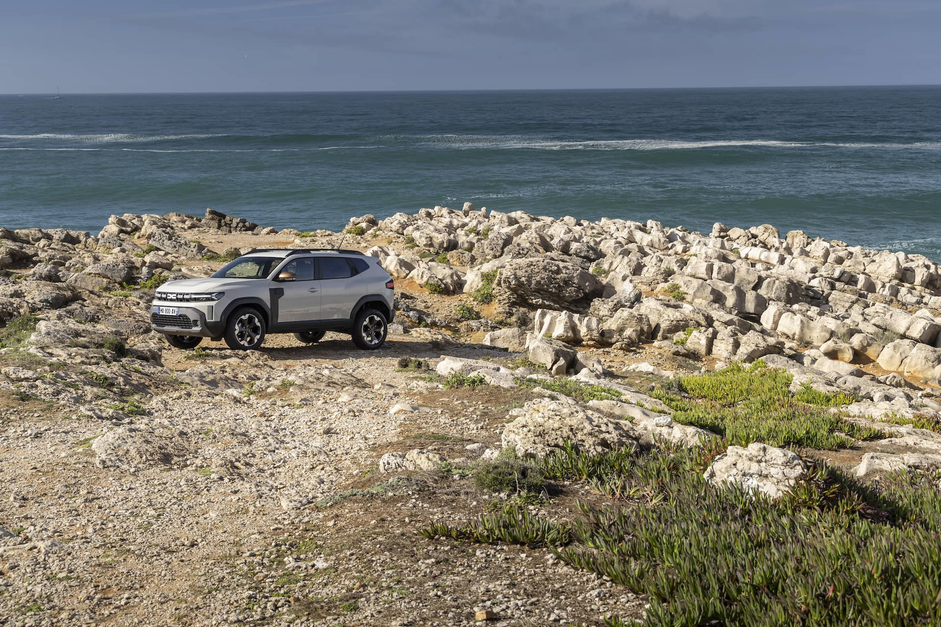 Vista lateral de un Dacia Duster en un entorno natural, resaltando su perfil todo terreno.