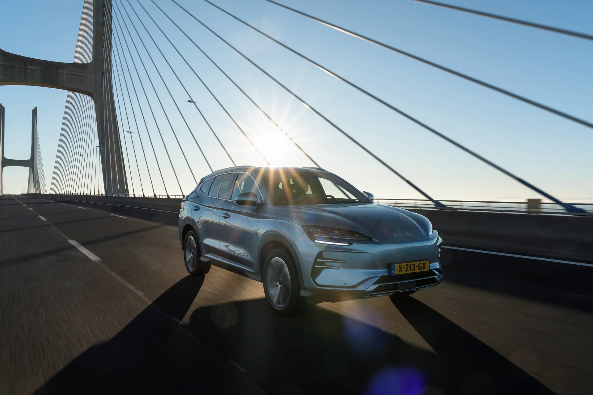 BYD Seal U avanzando por un puente al atardecer, vista delantera y lateral.
