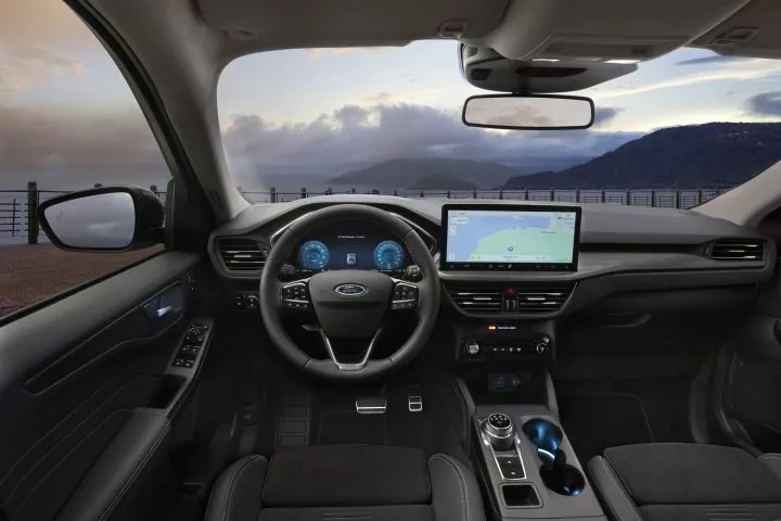 Panel de mandos y consola central del Ford Kuga, mostrando volante y pantalla de infotenimiento.