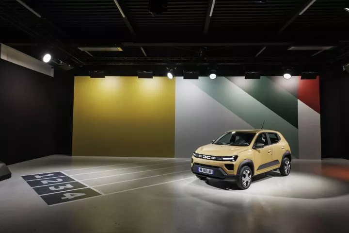 Dacia Spring en presentación con iluminación destacando su frontal y perfil.
