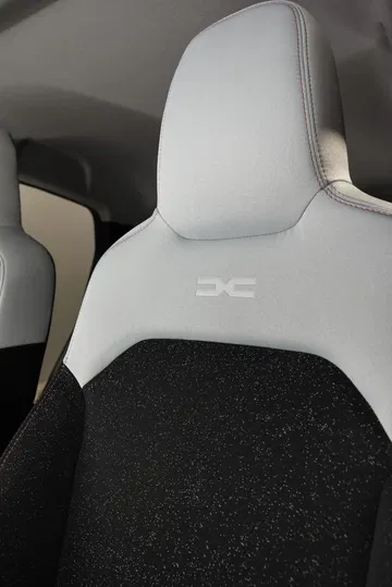Vista cercana del detalle del asiento con el distintivo 'DC' del Dacia Spring.