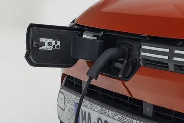 Toma cercana del punto de carga del Dacia Spring, ubicado en la zona frontal.