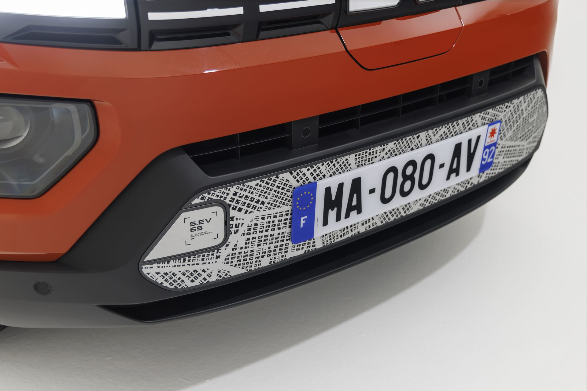 Primer plano del faro del Dacia Spring, mostrando su diseño y acabado.