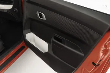 Vista parcial del panel de puerta del Dacia Spring, enfocado en mandos y materiales.