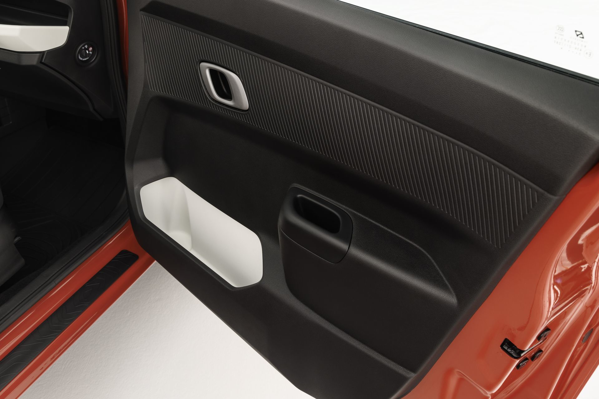 Vista parcial del panel de puerta del Dacia Spring, enfocado en mandos y materiales.