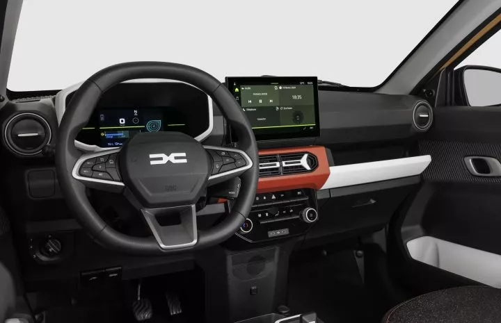 Vista detallada del salpicadero del Dacia Spring con énfasis en volante y sistema de infoentretenimiento.