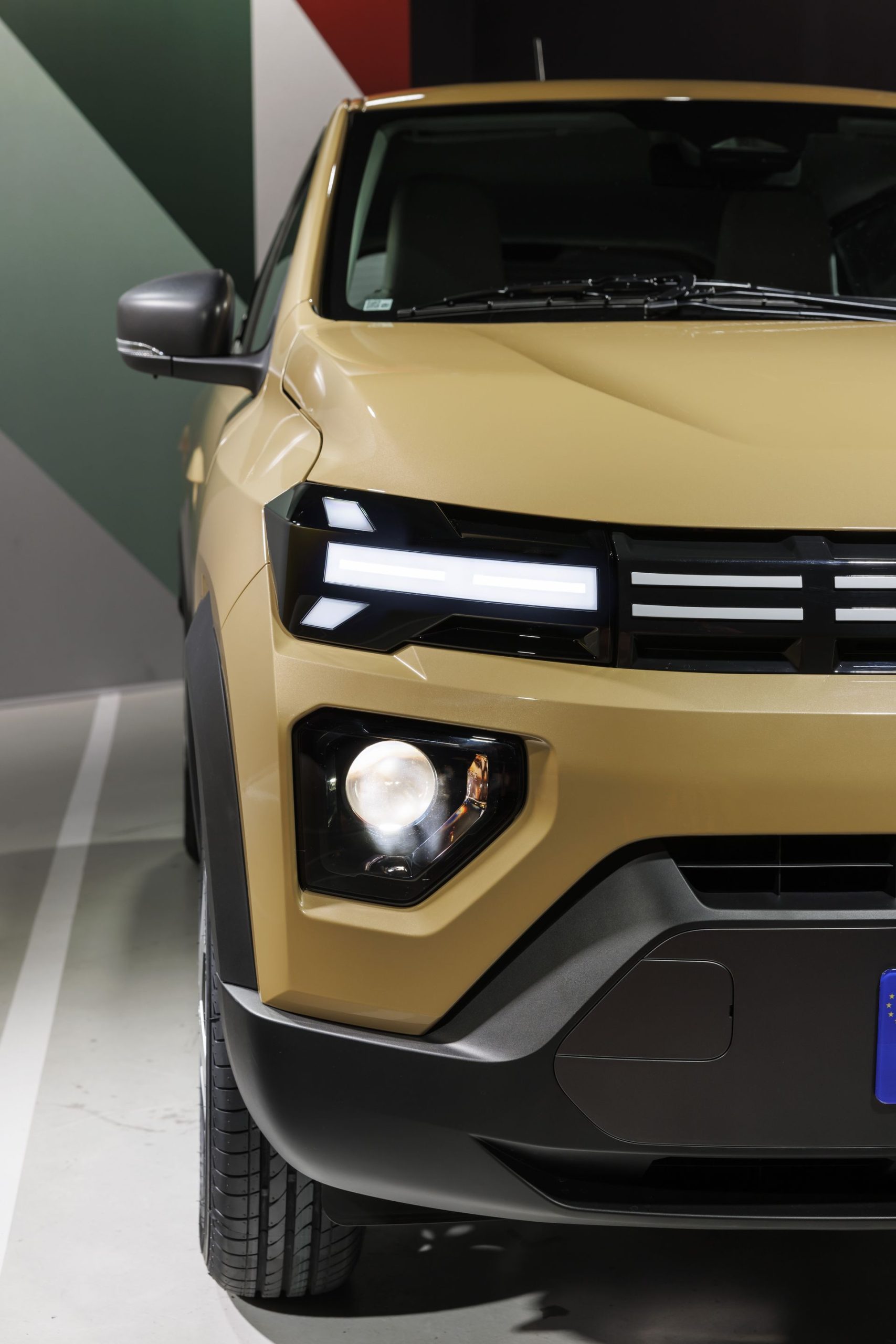 Fotografía primer plano de la parte delantera del Dacia Spring, destacando faros y parrilla.