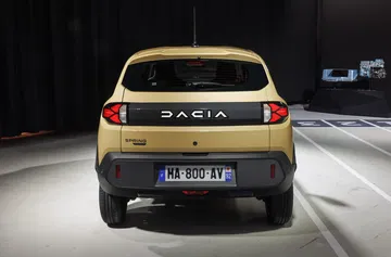 Visibilidad completa de la zaga del Dacia Spring, destacando sus grupos ópticos.