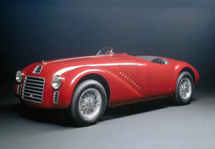 Vista lateral de un clásico deportivo con diseño atemporal y carrocería acabada en rojo.