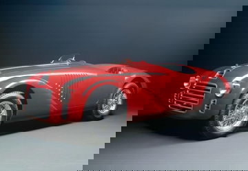 Vista lateral de un clásico deportivo con diseño atemporal y carrocería acabada en rojo.