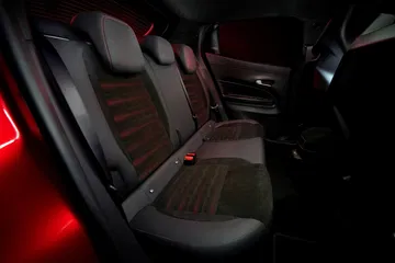 Vista nocturna de los asientos del Alfa Romeo Junior, con iluminación ambiental.