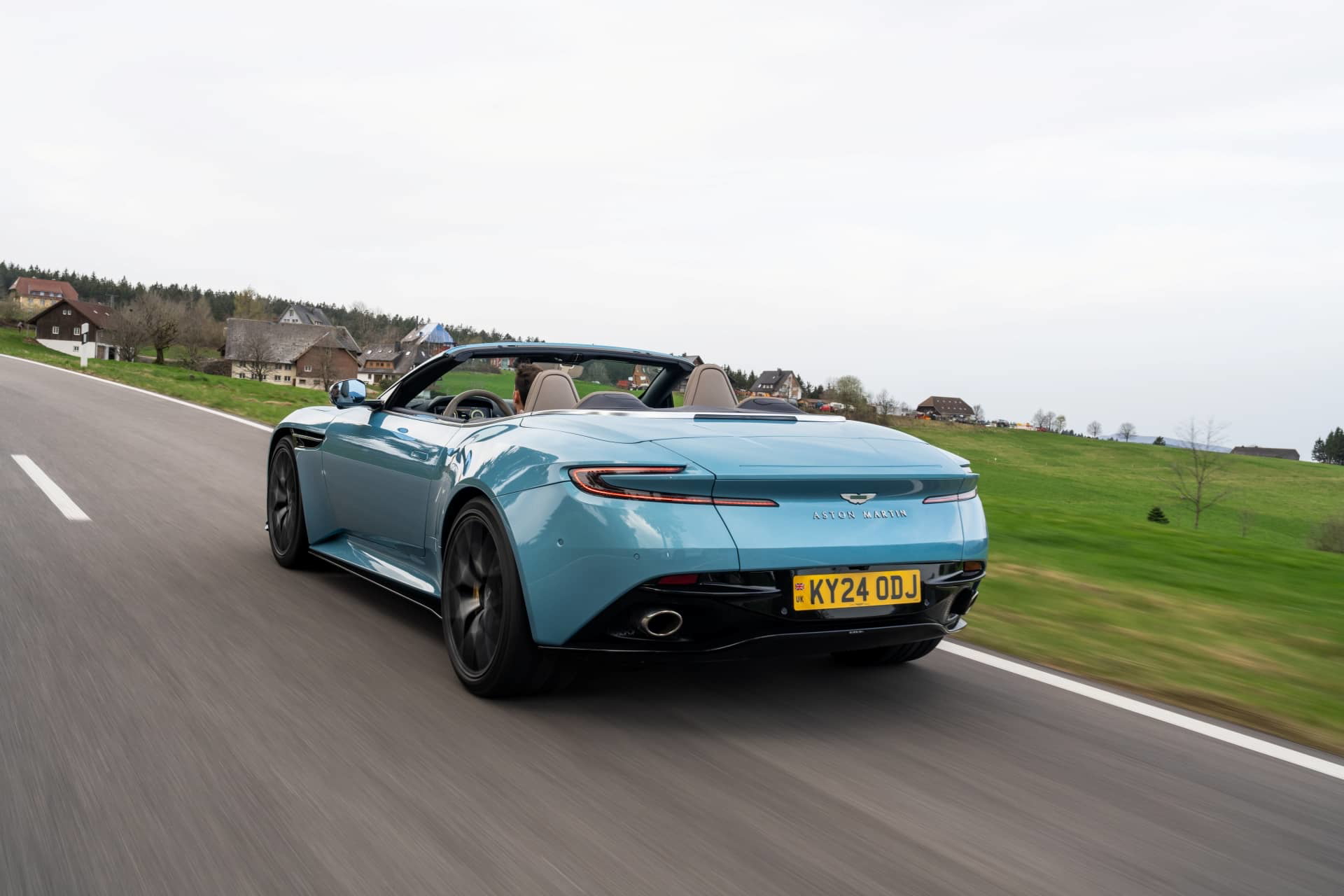 El Aston Martin DB12 Volante 2024 exhibiendo su dinámica silueta en movimiento.