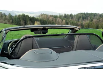 Vista trasera lateral del Aston Martin DB12 Volante con el techo plegado.