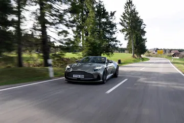 Aston Martin DB12 Volante capturado en movimiento, destilando elegancia y deportividad.