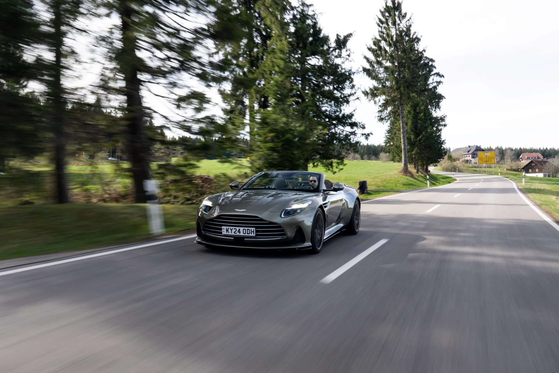 Aston Martin DB12 Volante capturado en movimiento, destilando elegancia y deportividad.