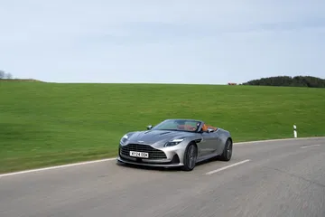 El Aston Martin DB12 Volante muestra su silueta elegante y deportiva en pleno movimiento.