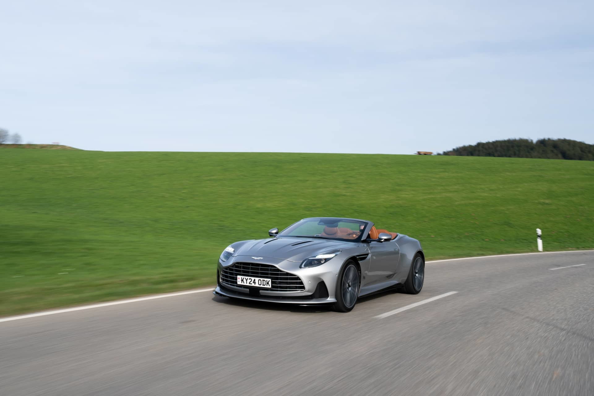 El Aston Martin DB12 Volante muestra su silueta elegante y deportiva en pleno movimiento.