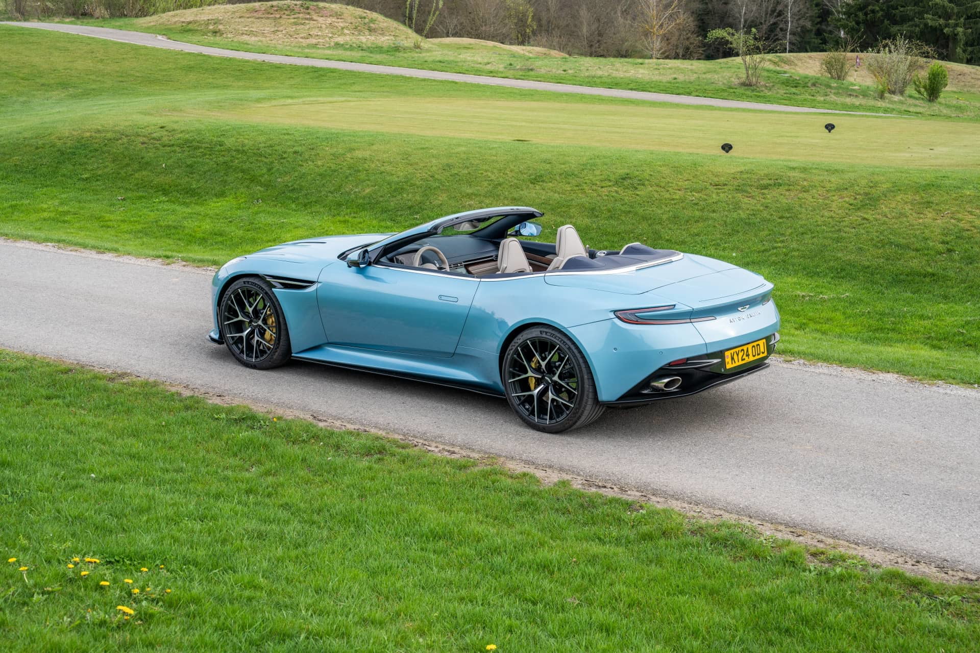 Vista lateral y trasera del Aston Martin DB12 Volante 2024, mostrando su elegante diseño.