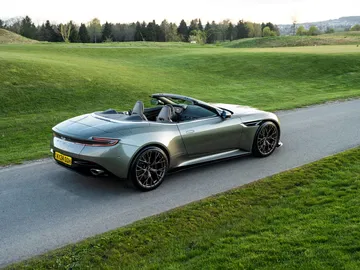 Aston Martin DB12 Volante en vista lateral y trasera, mostrando su elegante diseño y capota abierta.