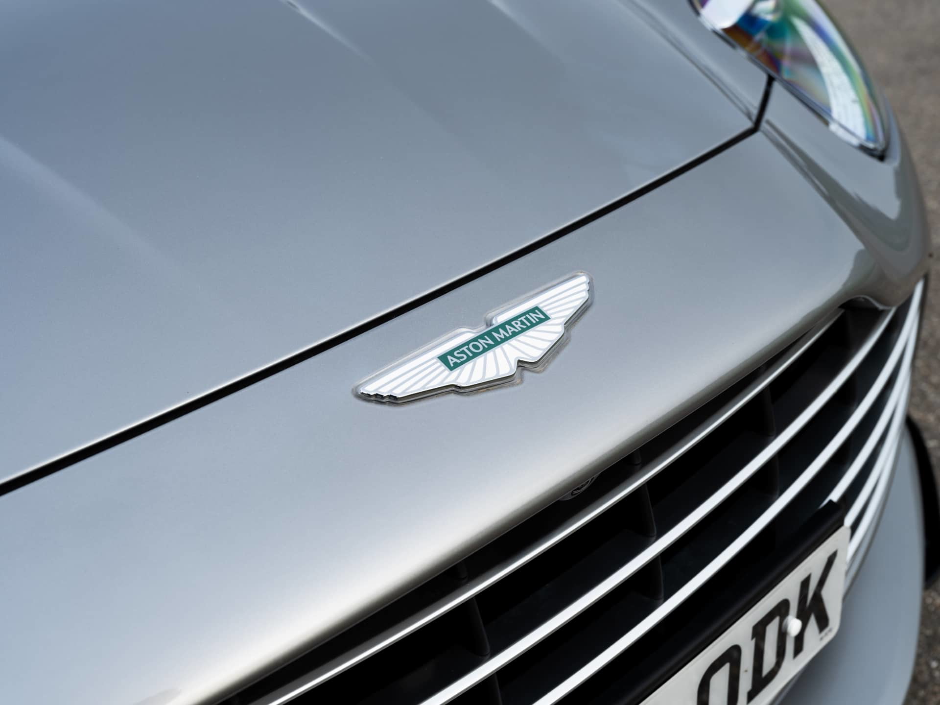 Vista cercana del emblema y parrilla del Aston Martin DB12 Volante.