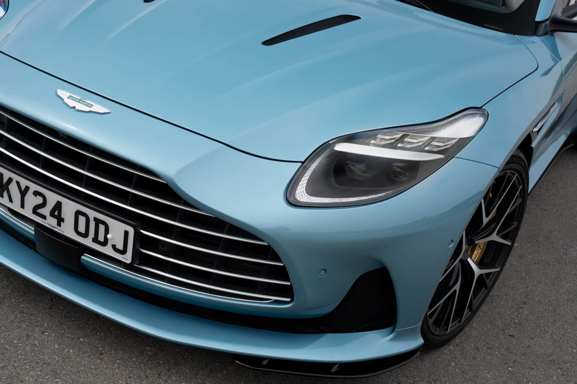 Vista frontal del Aston Martin DB12 Volante resaltando su icónica parrilla y faros elegantes.