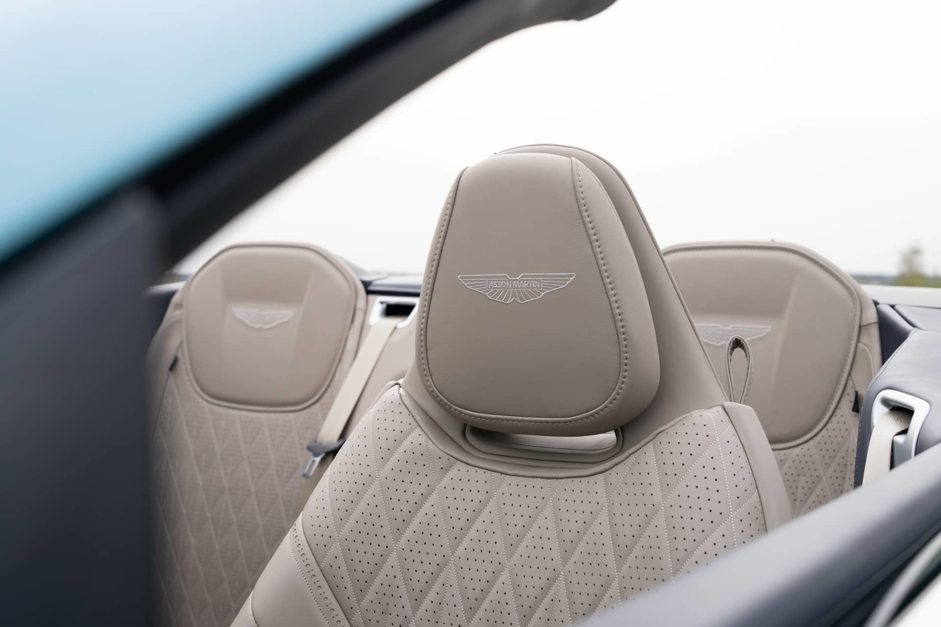 Vista detallada de los asientos de cuero con emblemático logo Aston Martin.