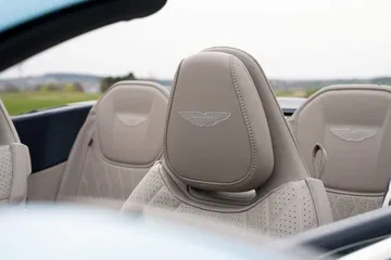 Vista de los asientos de piel perforada con el emblema de Aston Martin