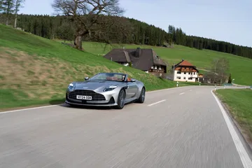 Aston Martin DB12 Volante captado dinámicamente en carretera abierta.