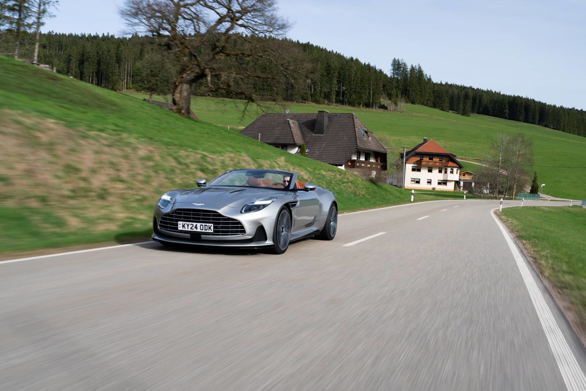 Aston Martin DB12 Volante captado dinámicamente en carretera abierta.