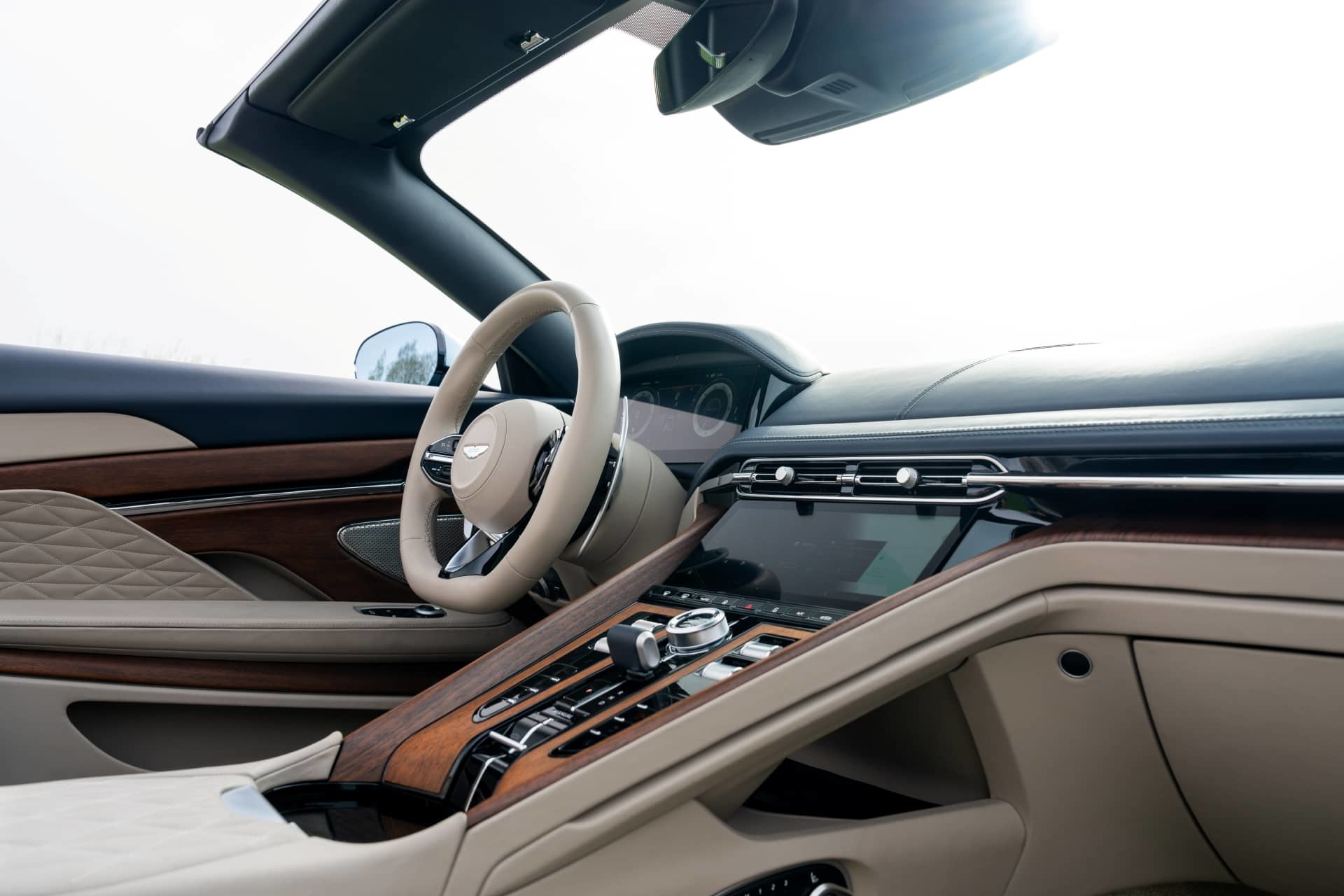 Vista lateral del lujoso habitáculo del Aston Martin DB12 Volante 2024, acabados de alta calidad.