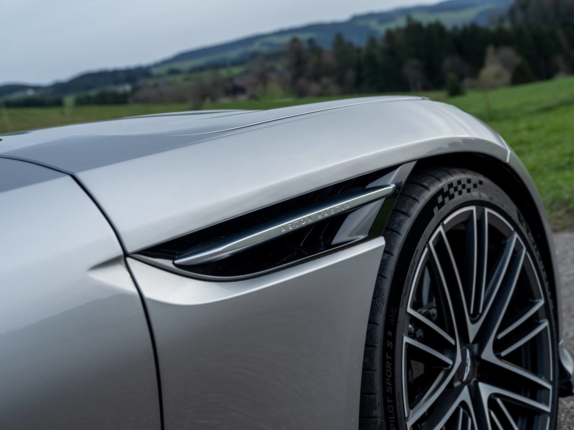 Acercamiento a la ventilación lateral y llanta del Aston Martin DB12 Volante 2024.
