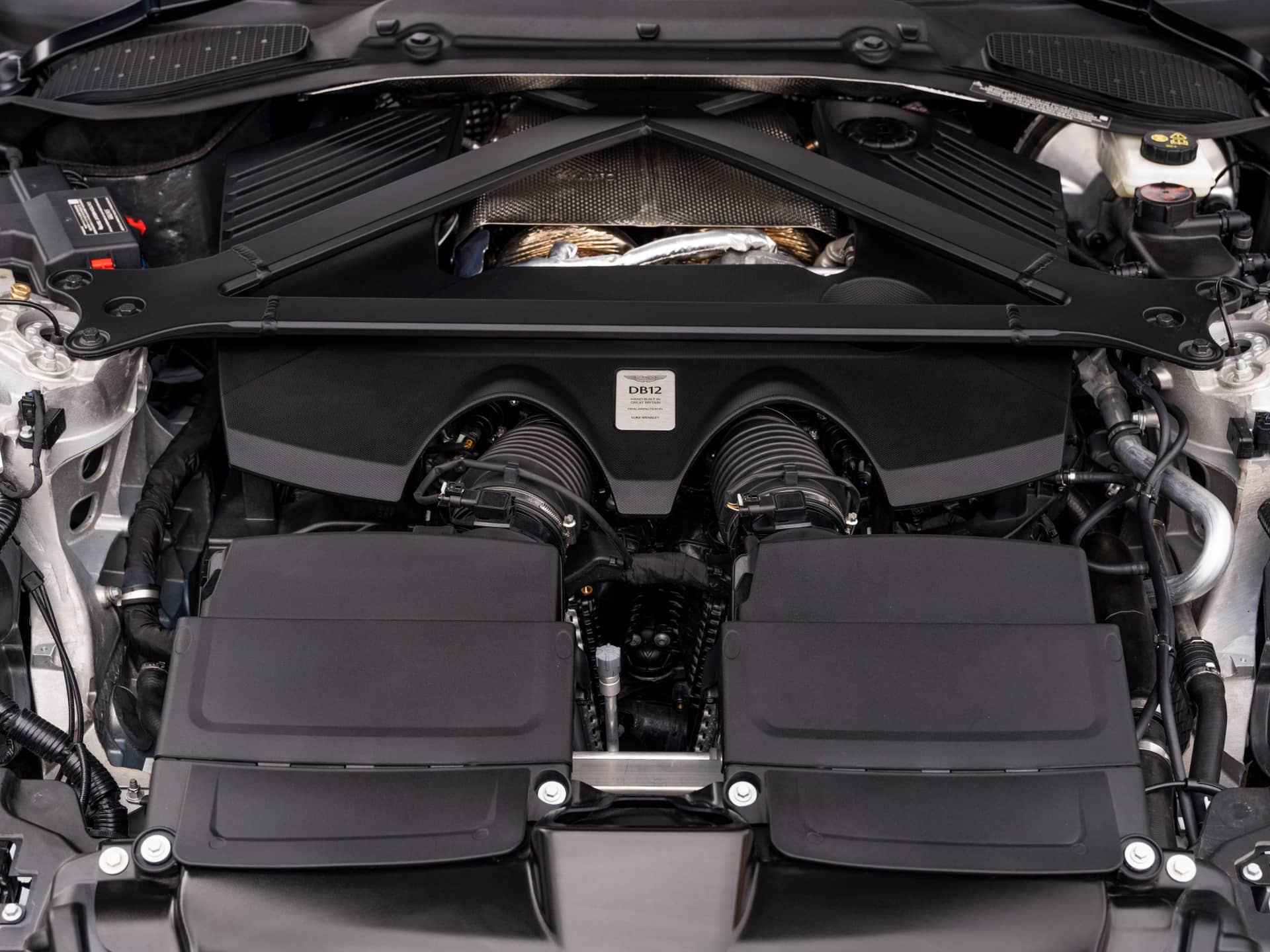 Vista detallada del propulsor V12 del Aston Martin DB12 Volante, una muestra de potencia y sofisticación.