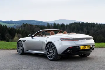 Vista trasera lateral del Aston Martin DB12 Volante en entorno natural.