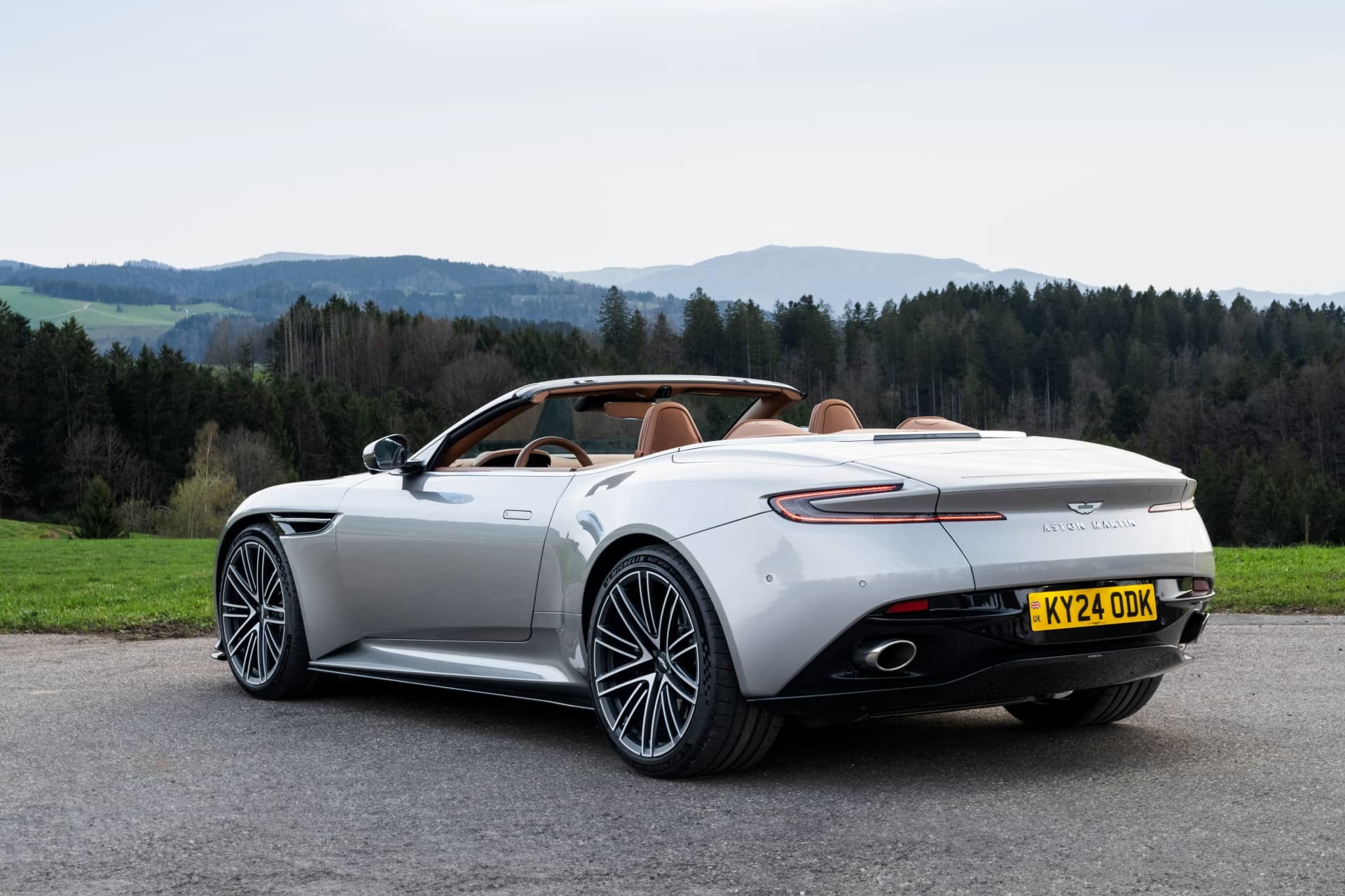 Vista trasera lateral del Aston Martin DB12 Volante en entorno natural.